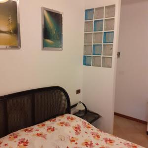 ラ・スペツィアにあるGiada Apartmentのベッドルーム1室(ベッド1台付)が備わります。壁に3枚の写真が飾られています。