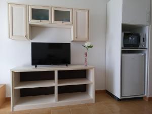 a living room with a tv on a white entertainment center at Las Torres Del Castillo-120 Palms in Costa de Antigua