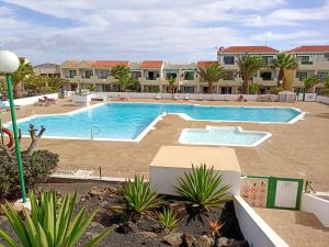 a large swimming pool in front of a resort at Las Torres Del Castillo-120 Palms in Costa de Antigua