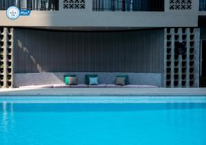 Cama con almohadas junto a la piscina en Reno hotel en Bangkok