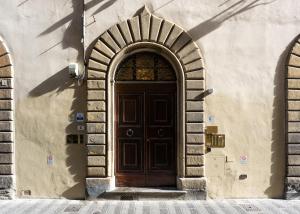 a wooden door in a building with two arches at Palazzo D'Ambra Residenza d'Epoca in Florence
