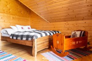 1 dormitorio con 1 cama en una cabaña de madera en Bacówka na Kubanówce, en Rdzawka