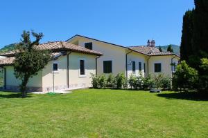 a large white house with a grass yard at LO SCRIGNO COUNTRY HOUSE in Coltodino