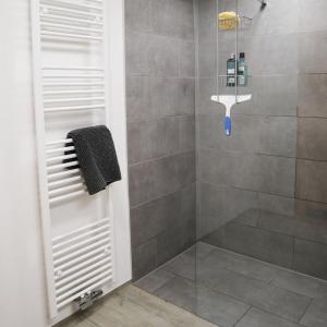 La salle de bains est pourvue d'une douche avec une porte en verre. dans l'établissement #staywild29 - Gemütliche Ferienwohnung im Allgäu, à Kempten