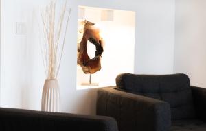 a living room with a couch and a chair and a vase at Porta Nova Suites Altea - Adults Only in Altea