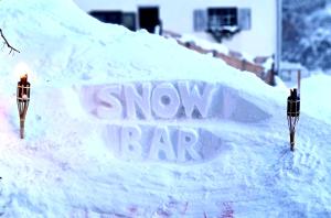 ein Schneebarschild im Schnee neben zwei Parkuhren in der Unterkunft Ferienhaus & Ferienwohnung Wiñay Wayna Gotschna Blick Klosters in Klosters Serneus