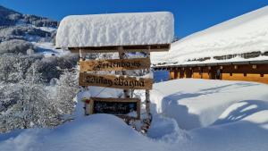a sign in the snow in front of a cabin at Ferienhaus & Ferienwohnung Wiñay Wayna Gotschna Blick Klosters in Klosters Serneus