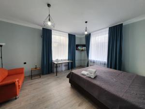 1 dormitorio con cama, sofá y ventanas en Park & Pedestrian zone apartment for4, en Chişinău