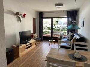 a living room with a couch and a television at Apart Inn Feldstrasse in Winterberg