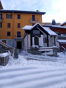 a building with snow on the ground in front of it at MadeBoutique Rooms in Madesimo