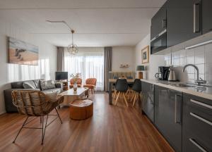 a kitchen and living room with a couch and a table at Appartementencomplex Motel Texel in De Koog