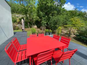 einen roten Tisch und Stühle auf einer Terrasse in der Unterkunft Villa Durandal in Souillac
