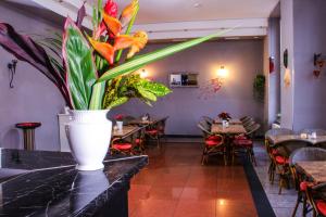 un ristorante con tavoli e un vaso con fiori su un bancone di Hotel Karlshorst a Berlino