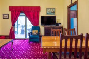 a living room with a dining table and a tv at Allora House Kalgoorlie in Kalgoorlie