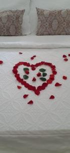 a heart made out of roses on a bed at Solar Gema da Serra in Petrópolis