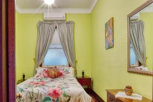 a bedroom with a bed with a window and a mirror at Allora House Kalgoorlie in Kalgoorlie