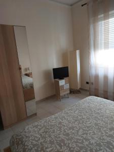 sypialnia z lustrem, łóżkiem i telewizorem w obiekcie COCO Apartments w Katanii