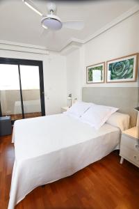 Un dormitorio con una gran cama blanca y una ventana en Alojamientos Libertad en Yecla