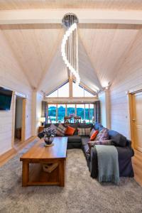 ein Wohnzimmer mit einem Sofa und einem Tisch in der Unterkunft Cuddfan Lodge on a Gorgeous Private Lake in Newport