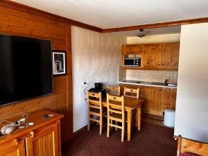- une cuisine avec une table et une télévision dans la chambre dans l'établissement Les Alpages location appartement 202, à Lanslebourg-Mont-Cenis