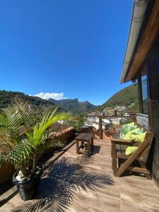 a patio with a table and a bench on a building at Casa Colona - Guesthouse in Petrópolis