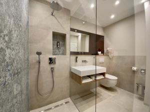a bathroom with a shower and a toilet and a sink at Hotel West an der Bockenheimer Warte in Frankfurt/Main