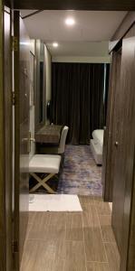 a bathroom with a sink and a chair in a room at لي لي النخيل للشقق المخدومة - درجة اقتصادية in Al Ahsa