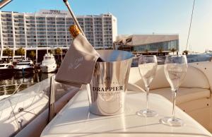 two wine glasses and a bucket on a table on a boat at Mr. Cliff Yachts in Quarteira