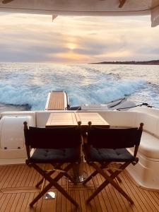 ein Boot mit zwei Stühlen und einem Tisch auf der Terrasse in der Unterkunft Mr. Cliff Yachts in Quarteira