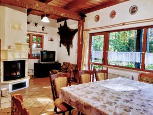 een eetkamer met een tafel en een open haard bij Villa Jolanta in Teerau