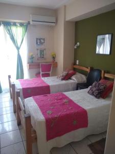 Habitación de hotel con 2 camas y ventana en Los Lapachos en San Miguel de Tucumán