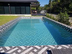 a swimming pool with a geometric design in a yard at The Balcony pool villa in Ban Khanong Phra Nua