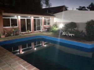a swimming pool in front of a house at night at La casa deMarta in Córdoba