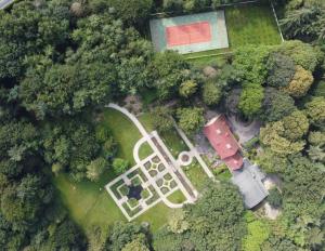 een uitzicht over de tuin met een huis en bomen bij Amsterdamgarden - Nardinclant - Laren NH in Laren