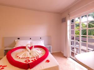 Un dormitorio con una cama con una decoración de corazón. en Hotel Pousada Ilha do Mar Bombinhas, en Bombinhas