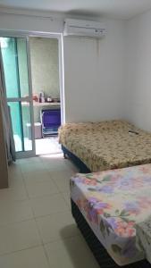 Giường trong phòng chung tại Flat beira mar com piscina e cascata