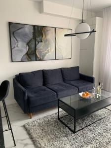 a living room with a blue couch and a glass table at NEW modern apartment in Uzhhorod