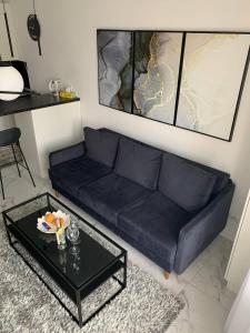 een blauwe bank in een woonkamer met een tafel bij NEW modern apartment in Oezjhorod