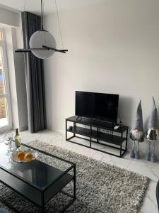 a living room with a tv and a table at NEW modern apartment in Uzhhorod