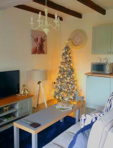 uma sala de estar com uma árvore de Natal no canto em Denver Cottage em Monyash