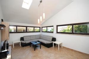 - un salon avec un canapé et quelques fenêtres dans l'établissement Apartament VV, à Pula