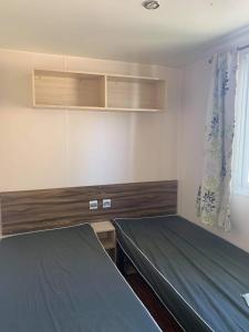 Habitación con 2 camas y ventana en Mobile home à louer 8 personnes en Valras-Plage