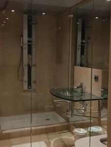 a bathroom with a glass shower and a sink at Bahia De La Plata Seafront in Estepona