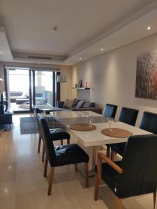 a dining room with a white table and chairs at Bahia De La Plata Seafront in Estepona