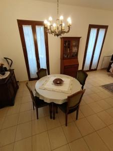 ein Esszimmer mit einem Tisch, Stühlen und einem Kronleuchter in der Unterkunft LE GINESTRE in Sulmona