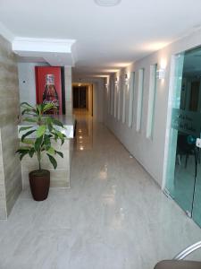 a hallway with a potted plant in a building at Hotel Uzi Praia in Recife