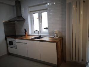 uma cozinha com um lavatório e uma janela em Casa Carmen 1 em Cudillero