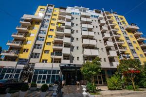 a tall apartment building with yellow and white at Hotel Miki in Durrës