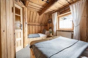 a bedroom with a bed and a window and a door at Domki Javorina in Zakopane