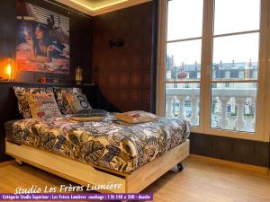 多勒Nos studios au centre ville à Dole的一间带床的卧室，配有大窗户